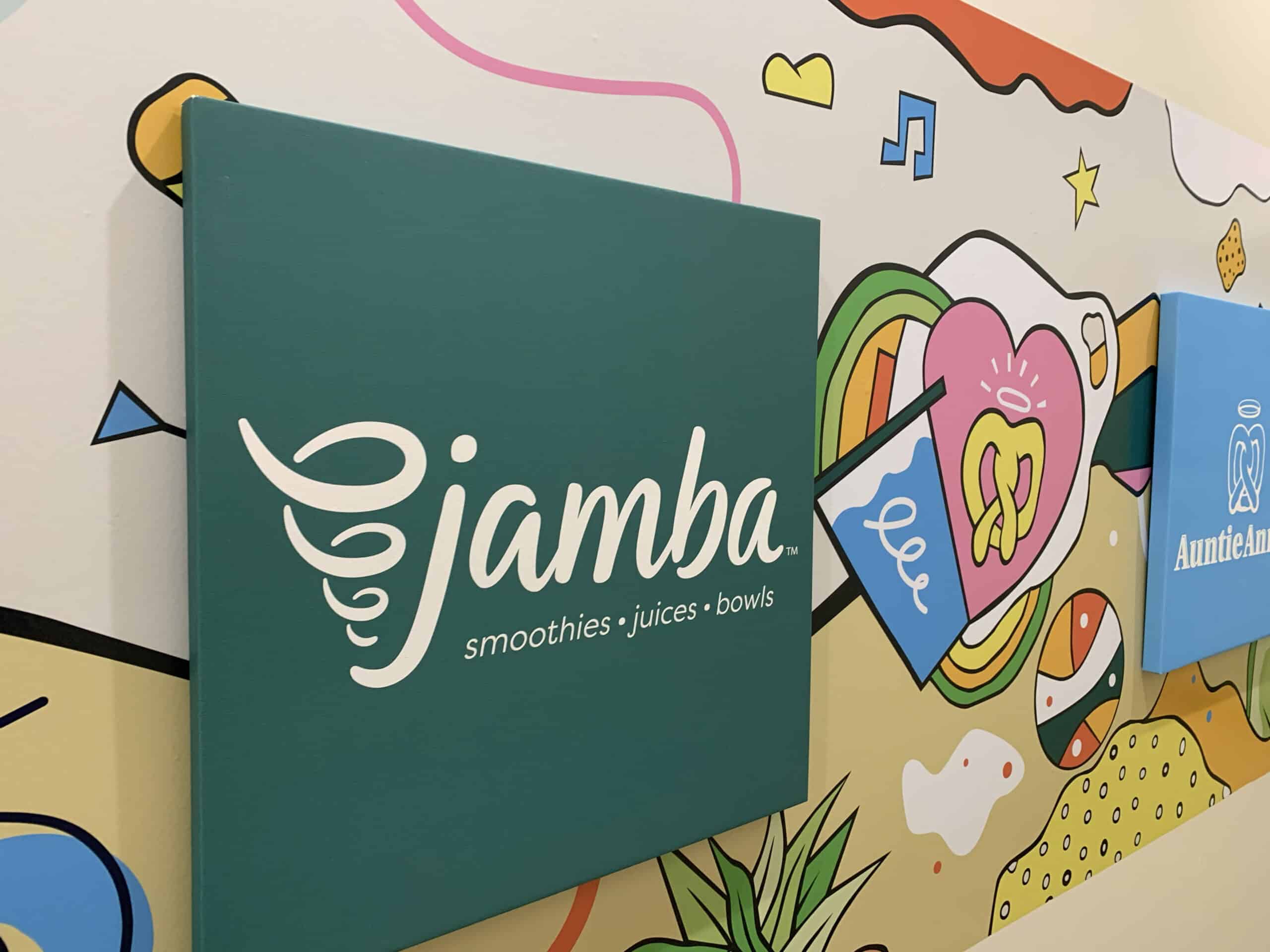 A colorful wall mural with playful shapes and icons features a green square sign displaying the Jamba logo and the words "smoothies • juices • bowls," perfect for those seeking creative inspiration for vehicle wraps Spring Grove, IL.
