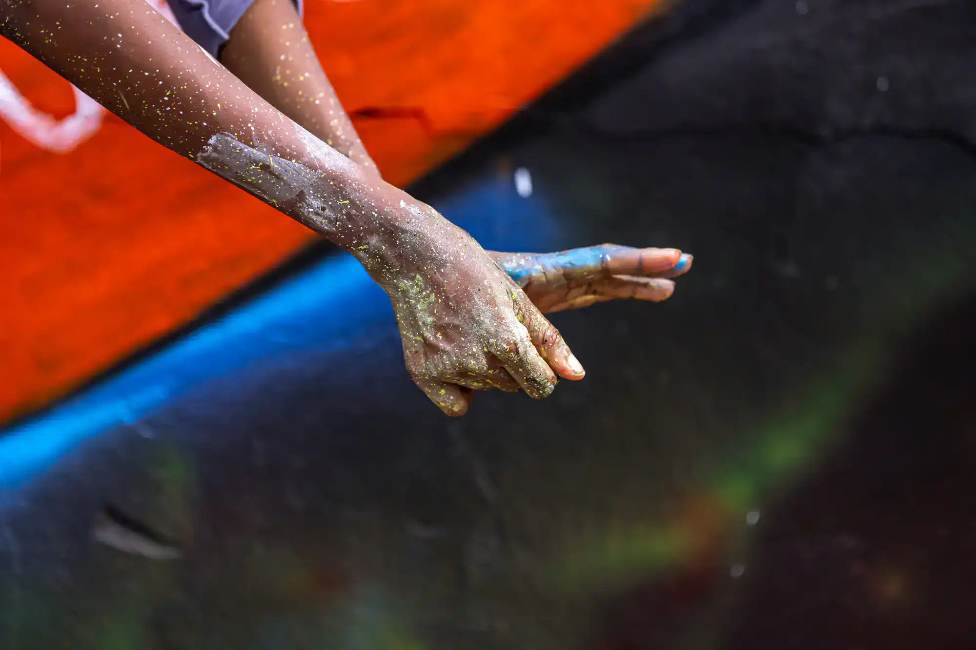 Two hands covered in glitter clap together against a vibrant, abstract background—reminiscent of the bold designs often seen on vehicle wraps Spring Grove, IL.